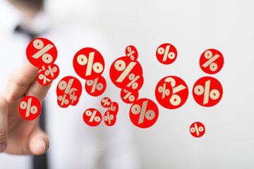 Image of a hand holding many red percentage symbols, ideal for discount, sale, and finance concepts.