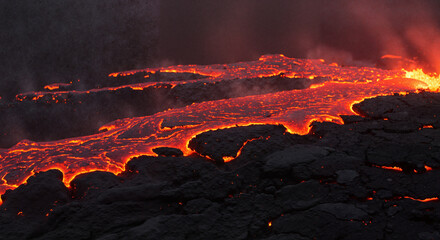 Flowing lava from volcano glowing in the dark night landscape  