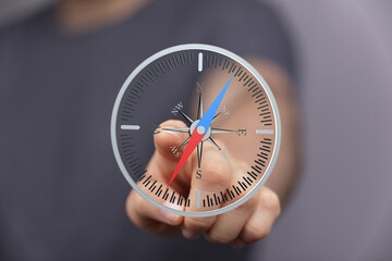 Hand pointing at a digital compass screen.  Navigation, direction, technology concept.