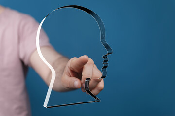 Hand pointing at a transparent head graphic.  Concept for AI, technology, or digital identity.