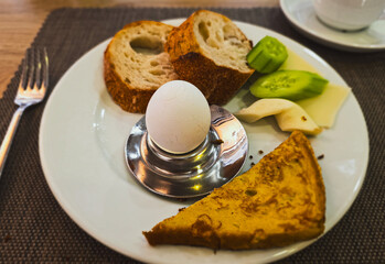 European breakfast plate with boiled egg, bread, vegetables and cheese