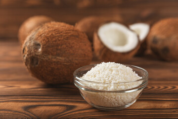 Set of fresh whole and half coconuts and slices on wooden background. Coconut flakes. Vegan....