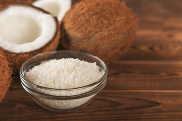 Set of fresh whole and half coconuts and slices on wooden background. Coconut flakes. Vegan. Tropical nut, fruit. Place for text. Copy space.