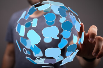 Abstract image of a man interacting with a digital sphere of speech bubbles, symbolizing global...
