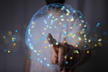 Abstract image of a hand interacting with a digital network sphere.  Represents connectivity, data,...
