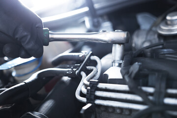 Auto parts. Professional mechanic with torque wrench fixing car indoors, closeup