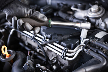 Auto parts. Professional mechanic with torque wrench fixing car indoors, closeup
