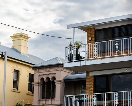 plants on balcony of three storey brick house by the coast with power cable connecting to home