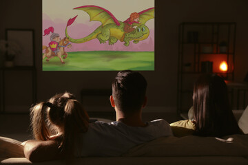 Family watching cartoon using video projector on sofa in evening