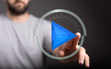 Person interacting with a 3D play button interface.  Modern technology, media, and digital concepts.