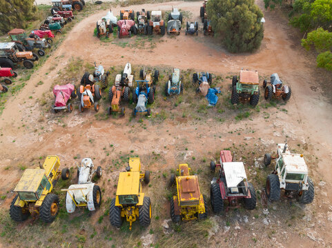 Aerial view of colourful rusty tractors parked in rows