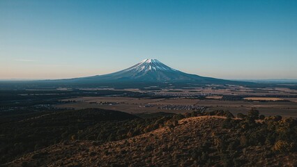 Fototapeta premium Aerial view of a mountain range under a clear sky with fields and natural scenery