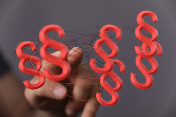 Abstract image of red paragraph symbols interconnected, representing legal concepts, law, and...
