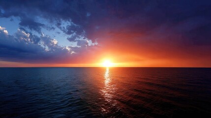 Obraz premium Breathtaking Sunset Over Calm Ocean Waters with Dramatic Clouds and Vibrant Sky Colors