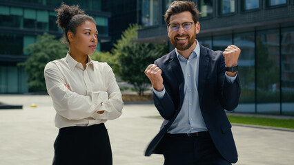 Two multiracial business colleagues different emotions in city African American woman businesswoman...