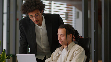 Business intern worker man working with laptop in office African American leader boss mentor coming...