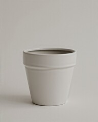 Minimalist white ceramic pot with drainage hole on plain white background