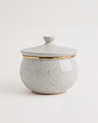 Speckled ceramic round pot with modern lid on plain white background