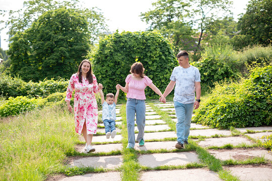 Parents, holding hands or happy kids walking in park and weekend fun. Family, outdoor and mom with boy, girl or father , smile in garden