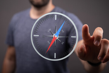 Stock photo of a man interacting with a digital compass, showing direction and navigation.