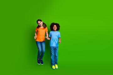 Diverse friends having fun together while smiling joyfully against a vibrant green backdrop during...