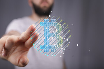 Image of a man's hand interacting with a digital Bitcoin hologram. Perfect for cryptocurrency,...
