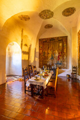 Medieval dining room showcasing a set table, antique tapestry, and vaulted ceiling in Svihov Castle, Czechia