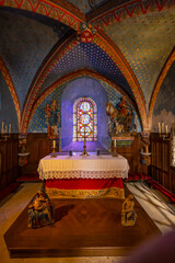 Interior of the Chateau de Commarin chapel showing altar, stained glass window and statues in...