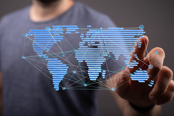 High-quality stock photo of a person interacting with a digital world map illustrating global...