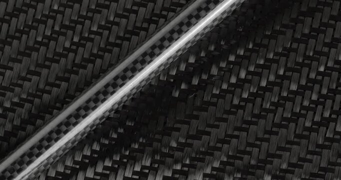 Carbon fabric and a carbon tube in close-up on a rotating table. Raw materials for carbon production.