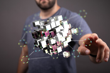 Abstract image of a man interacting with a digital cube network, representing data, technology, and...
