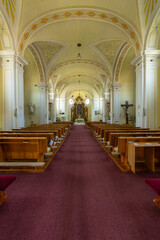 Interior of Church of Saint Bartholomew in Vnorovy, Czechia, showing vaulted ceiling and wooden pews