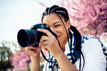 Young female photographer capturing moments outdoors in a springtime blooming park