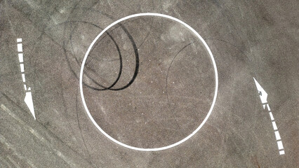 Kreisverkehr mit Reifenspuren und Straßenmarkierungen aus der Vogelperspektive