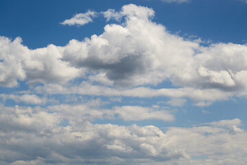 Light Cumulus congestus against the rich blue sky creates a powerful visual dynamic. Used in themes of ecology, weather forecasting, tourism, and life journey.