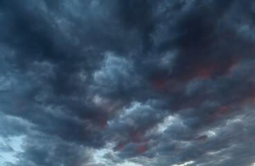 Dark clouds with bloody red streaks resembling cracks in reality, destruction of boundaries.