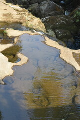 Clear water over smooth riverbed rocks, perfect for natural patterns and tranquility.