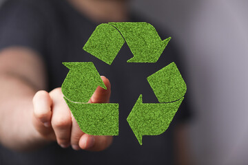 Sustainable eco-friendly recycling concept.  Person interacts with a green recycling symbol.