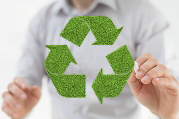 Person drawing a green recycling symbol. Eco-friendly, sustainability concept.