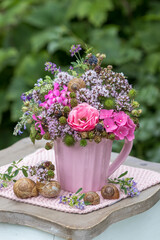 Blumen-Arrangement mit pink Rose, Hortensienblüten, Feldthymian und Brombeeren in Porzellantasse