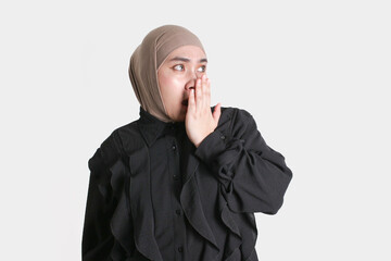 Surprised Muslim woman in hijab covering her mouth with hand, expressing shock or unexpected...