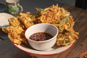 Indonesian food bakwan or vegetable fritters served with sambal. Perfect for traditional food menu, street snack photography, or Southeast Asian cuisine