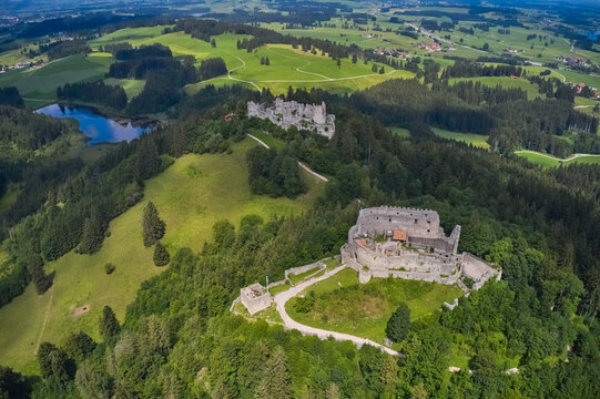 Aerial view of the old castle ruins standing tall against a backdrop of green hills and a tranquil lake, Eisenberg, Bavaria, Germany.