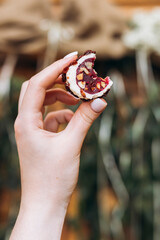 Hand holding bitten cheese snack with nuts and berries close-up.