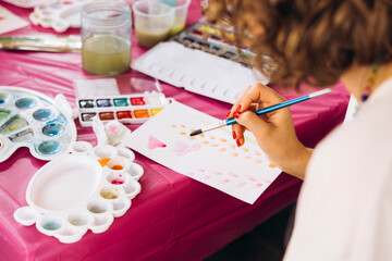 Woman painting with watercolor at art workshop, creative hobby concept.