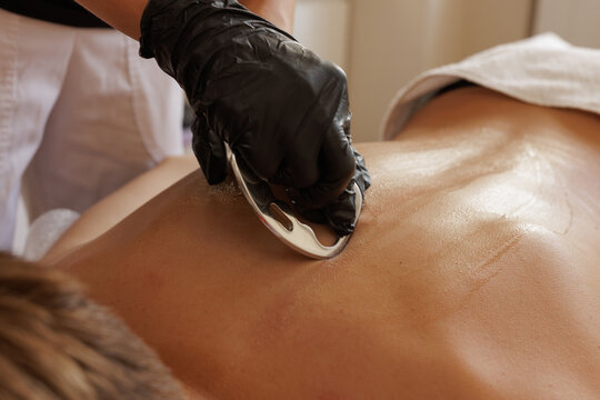 Massage Therapist Performing IASTM Metal Scraping Technique for Myofascial Release and Sports Recovery