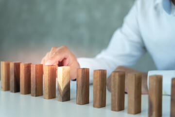 insurance with hands protect domino. Businessman hands stop dominoes falling in business crisis....