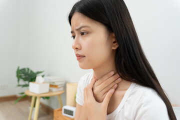 Asian woman put on neck due to a sore throat. female tonsillitis causes a inflammation. treated by...