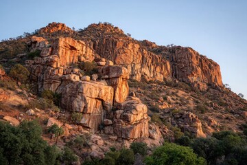 Majestic rocky mountain landscape at sunset with warm hues illuminating the rugged terrain