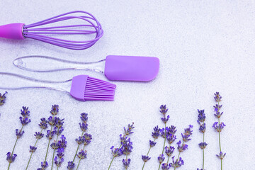 Purple kitchen tools with fresh lavender on a light background create a charming culinary setting